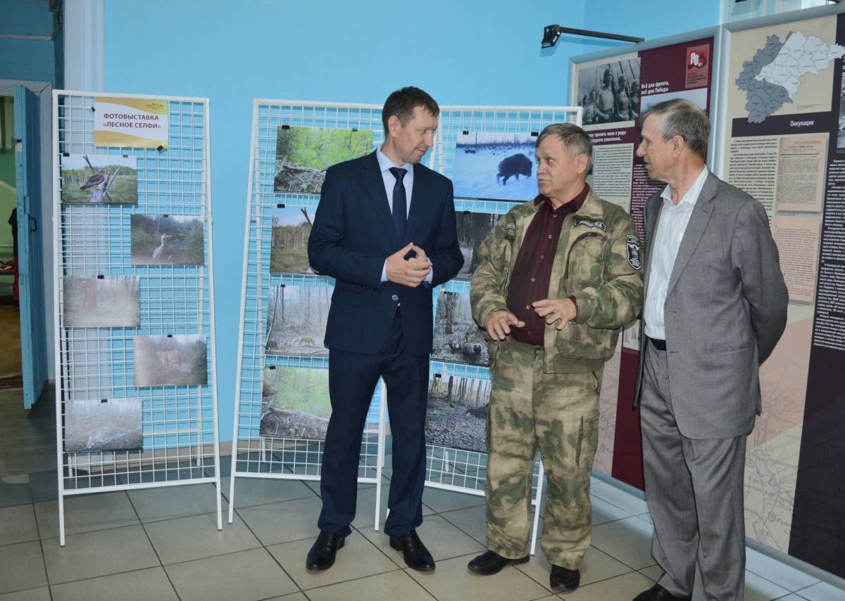 У фотовыставки в фойе бывший директор заповедника Владимир Кроликов (справа) и нынешний руководитель «Рдейского» Александр Кузнецов (слева), в центре — сотрудник заповедника Юрий Иванов